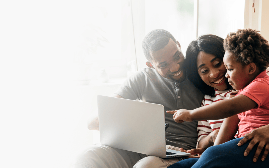 parents sitting at a computer with their child